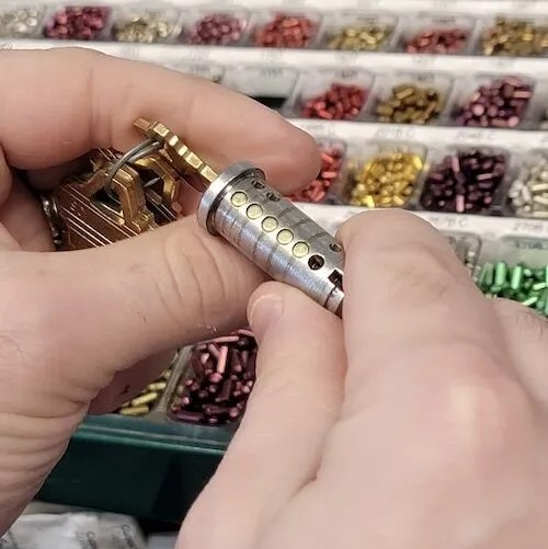 A locksmith rekeys a lock cylinder.