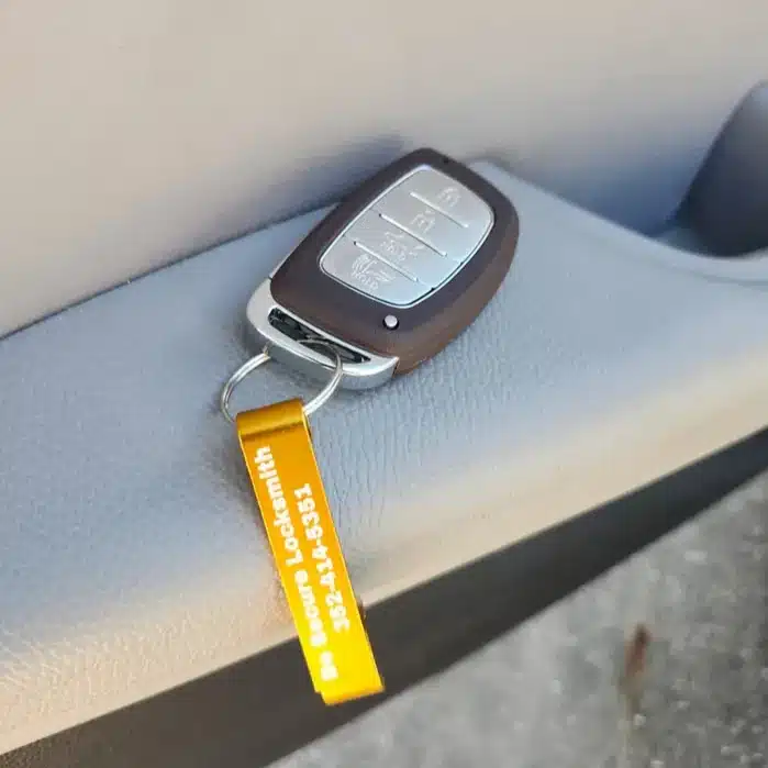 A car key fob sits on a car door armrest.